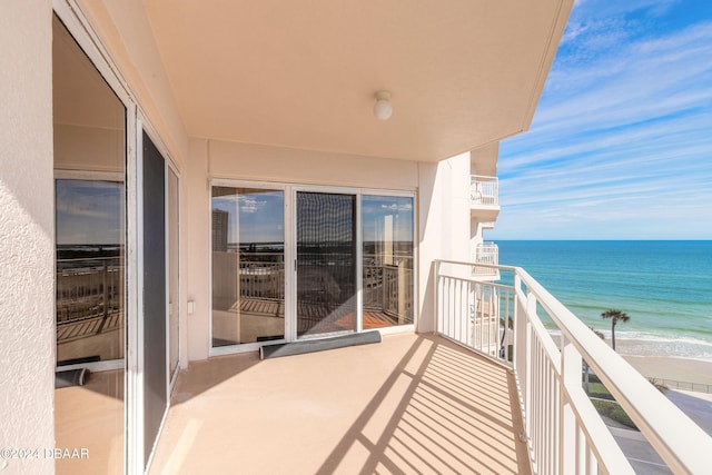 balcony featuring a water view and a beach view