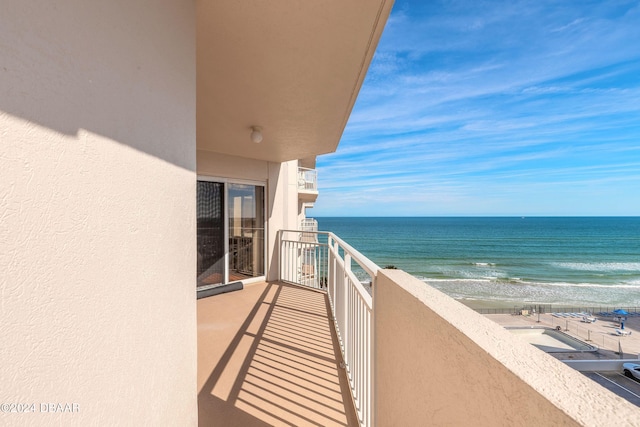 balcony featuring a beach view and a water view