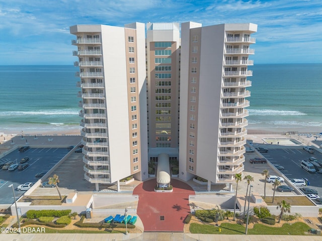 view of building exterior featuring a water view and a view of the beach