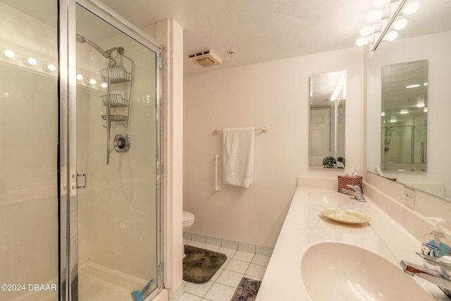 bathroom featuring toilet, tile patterned floors, vanity, and a shower with shower door