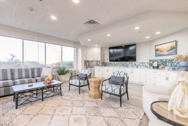 living room with a drop ceiling and light hardwood / wood-style flooring