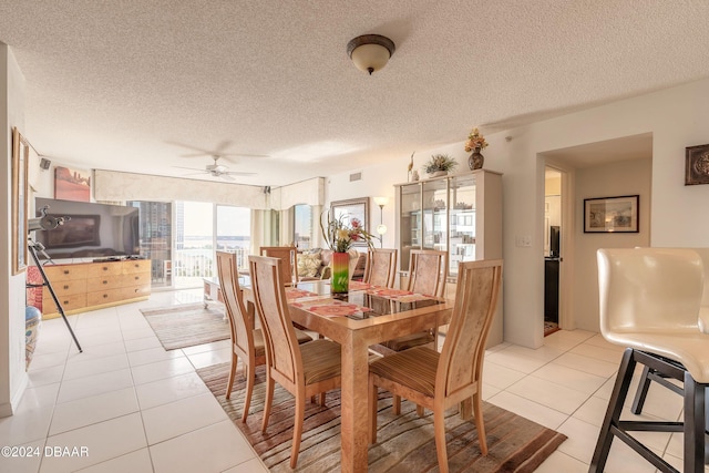 dining space with floor to ceiling windows, a textured ceiling, light tile patterned floors, and ceiling fan