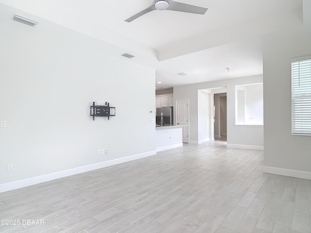 unfurnished living room featuring ceiling fan and light hardwood / wood-style flooring