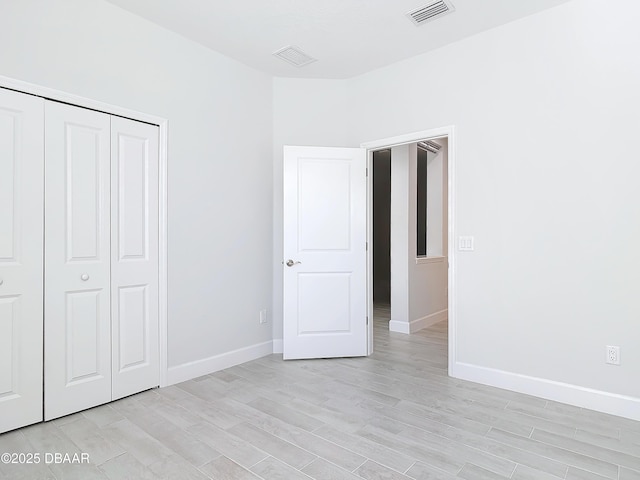 unfurnished bedroom with a closet and light hardwood / wood-style flooring