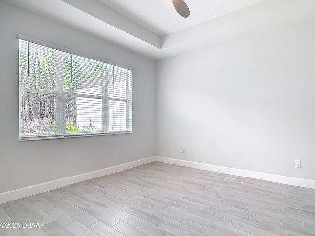 empty room with ceiling fan and light hardwood / wood-style floors