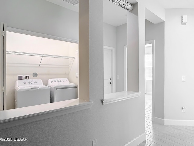 clothes washing area featuring hardwood / wood-style flooring and washing machine and dryer