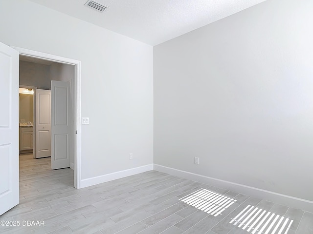 unfurnished room with light wood-type flooring