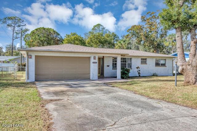 ranch-style home with a garage and a front lawn