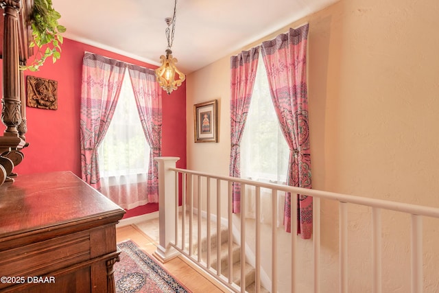 interior space with light wood finished floors and an upstairs landing