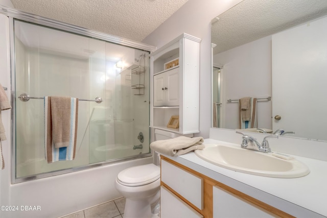 full bathroom featuring tile patterned flooring, enclosed tub / shower combo, a textured ceiling, toilet, and vanity