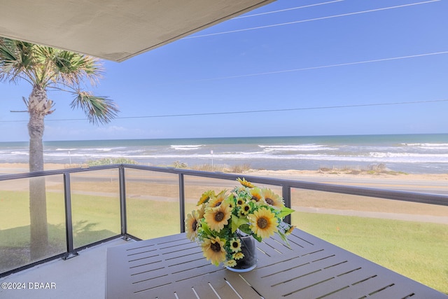 balcony with a water view and a view of the beach