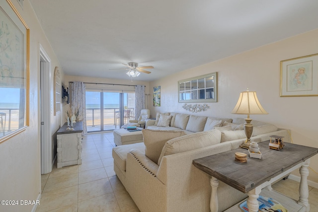 living room with a water view, light tile patterned floors, and ceiling fan