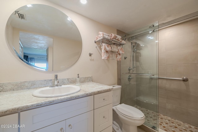 bathroom featuring vanity, walk in shower, and toilet