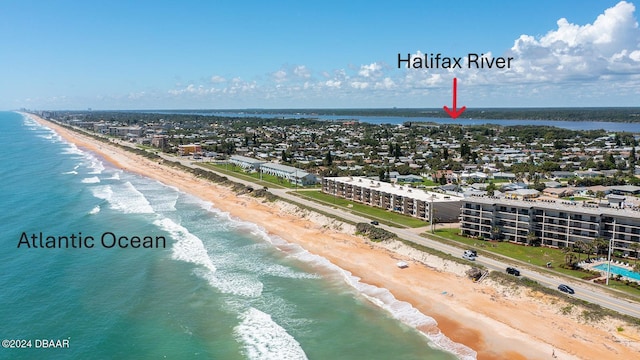 birds eye view of property with a water view and a beach view