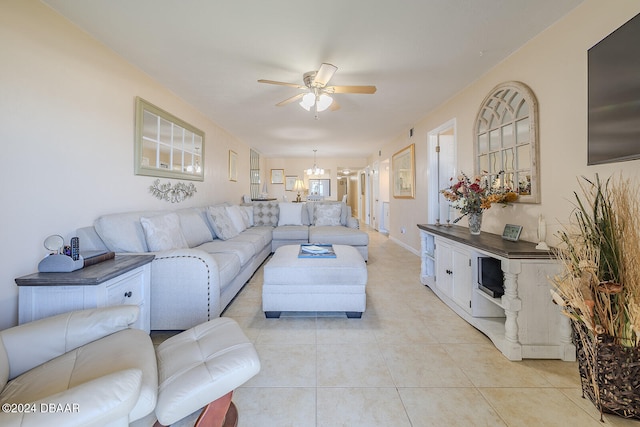 living room with light tile patterned floors and ceiling fan with notable chandelier