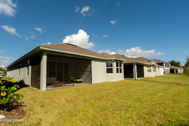 rear view of property featuring a sunroom and a yard