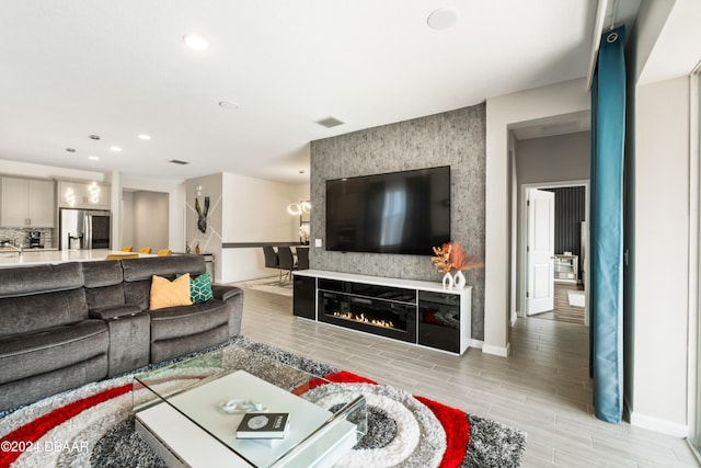 living room featuring a large fireplace and light hardwood / wood-style flooring