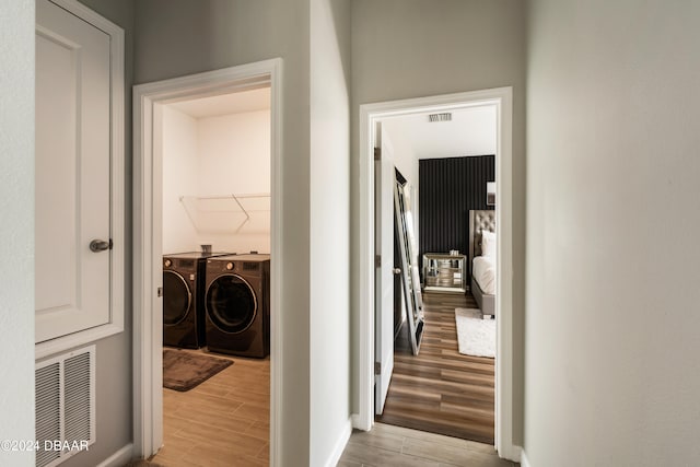 hall with light hardwood / wood-style flooring and washer and dryer