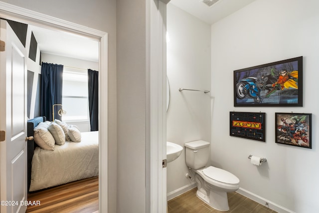 bathroom with toilet and wood-type flooring