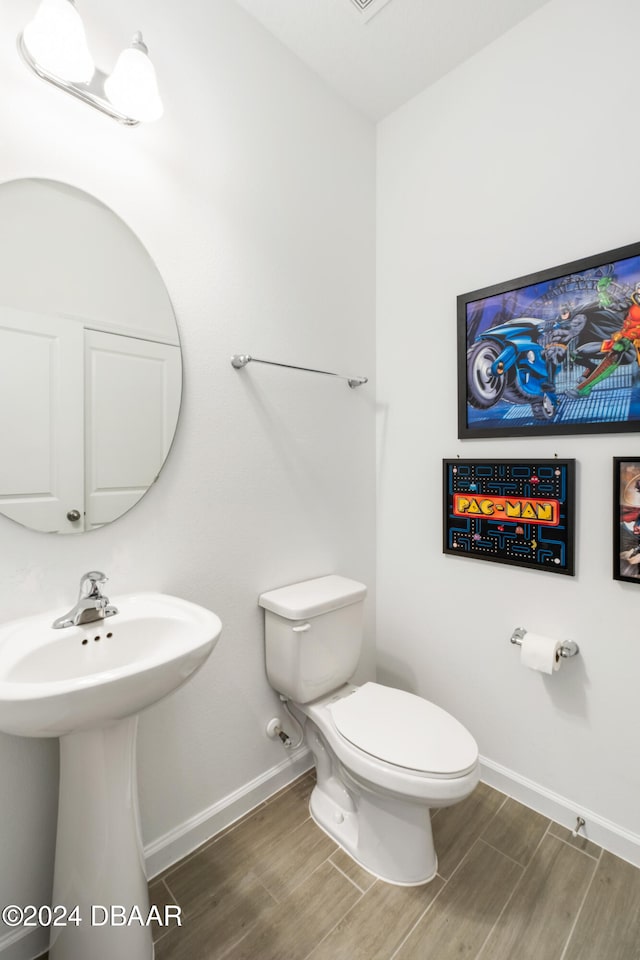 bathroom featuring hardwood / wood-style flooring and toilet