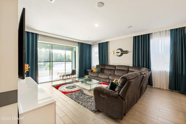 living room with a textured ceiling and light wood-type flooring