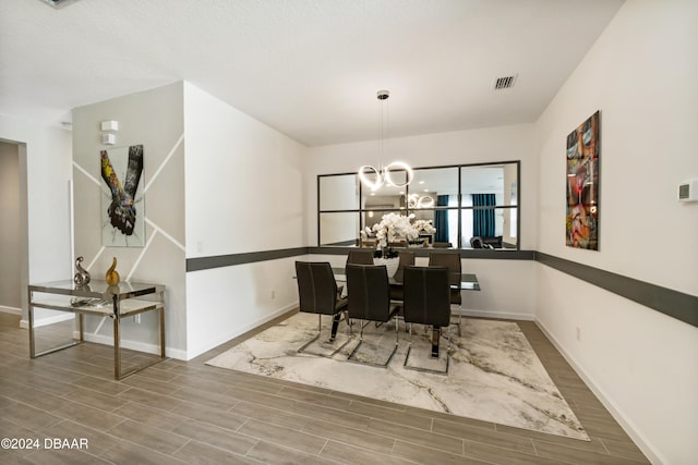 dining space with hardwood / wood-style flooring and an inviting chandelier