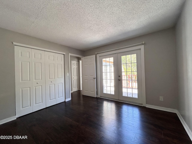 unfurnished bedroom featuring dark wood-style floors, french doors, a closet, baseboards, and access to exterior