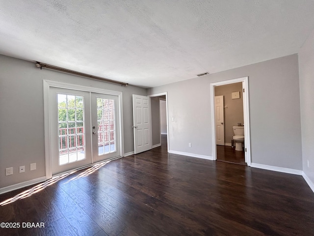 unfurnished room with wood finished floors, baseboards, visible vents, french doors, and a textured ceiling