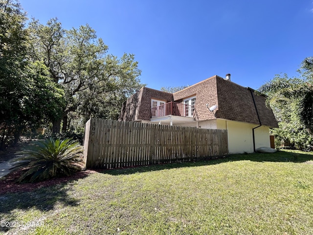 exterior space featuring a balcony and fence