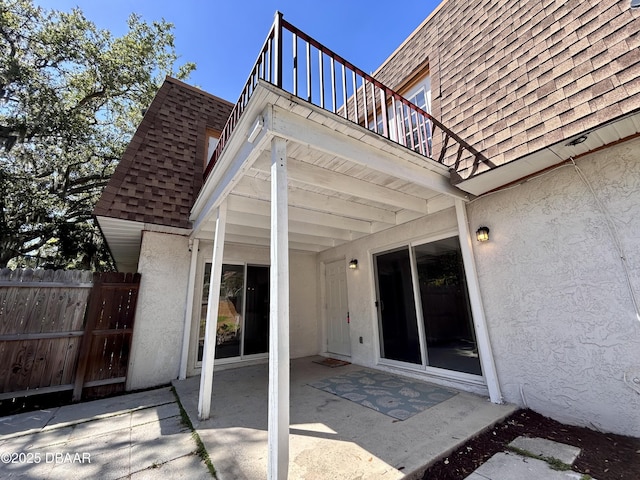 view of patio / terrace with a balcony and fence