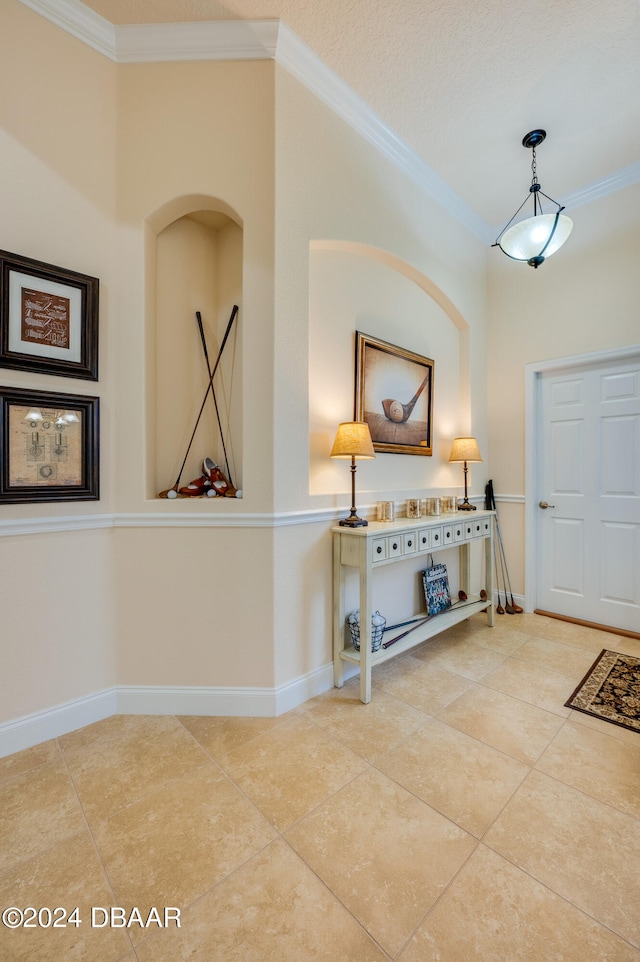 tiled entrance foyer featuring ornamental molding and a textured ceiling