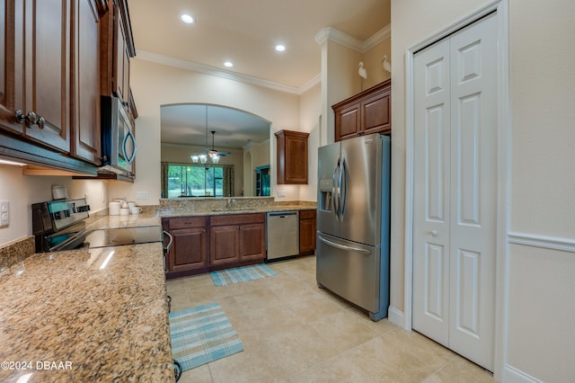 kitchen with stainless steel appliances, light stone counters, sink, crown molding, and decorative light fixtures