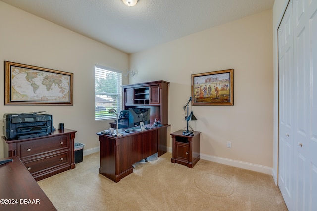 carpeted home office featuring a textured ceiling