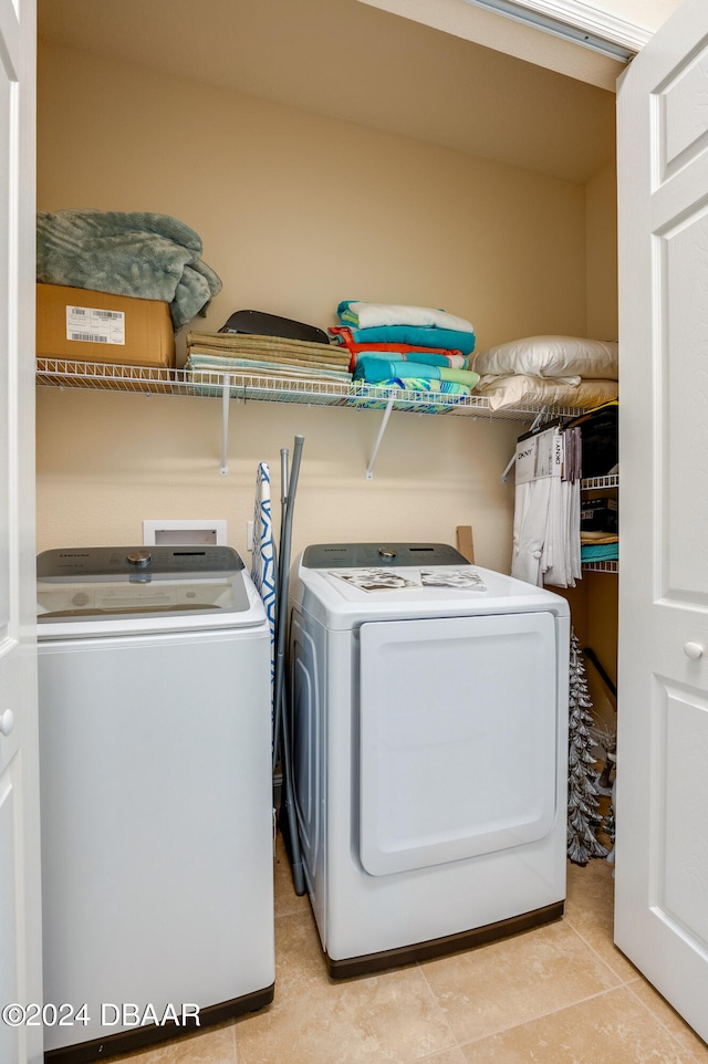 laundry area with light tile patterned flooring and washer and dryer