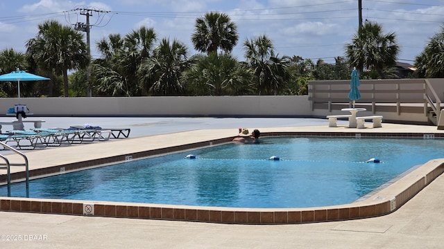 pool with fence and a patio