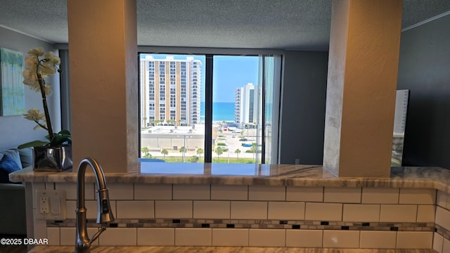 interior details with a textured ceiling and a water view