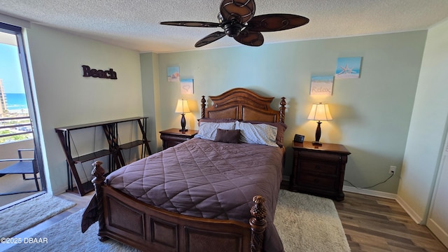 bedroom with a textured ceiling, ceiling fan, wood finished floors, and baseboards