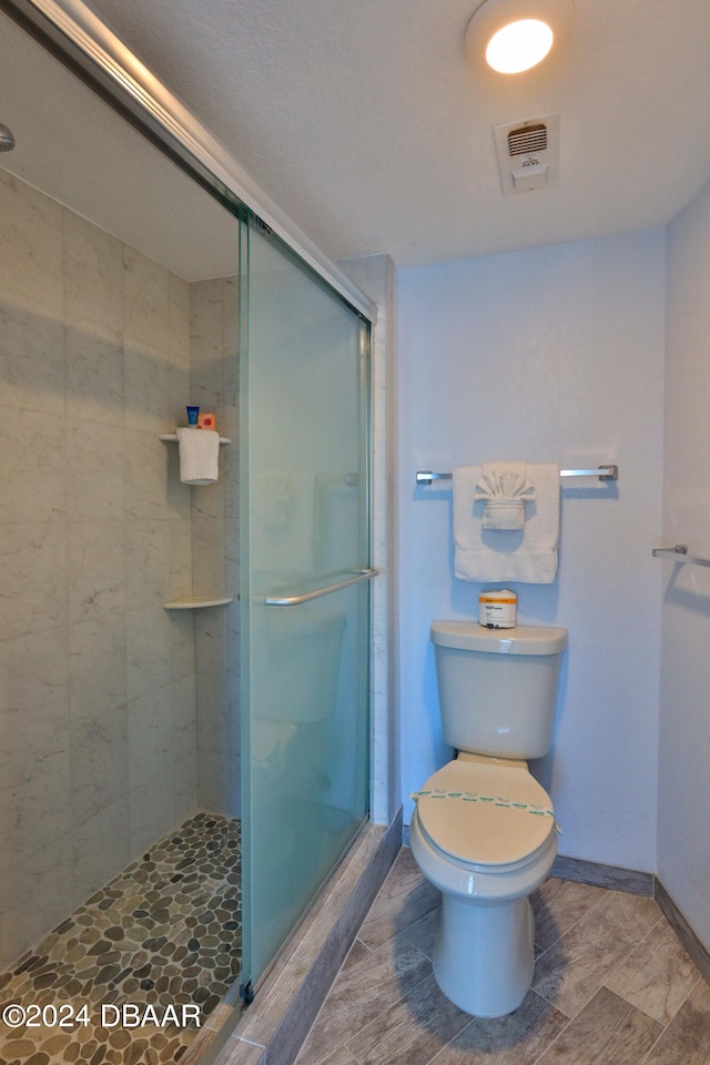 bathroom with toilet and an enclosed shower