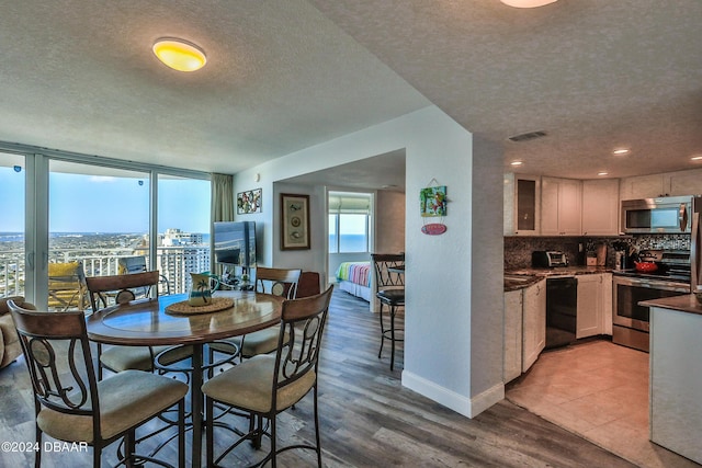 2625 S Atlantic Ave Unit 25Nw, Daytona Beach Shores, FL 32118 - dining room with a textured ceiling, wood finished floors, and baseboards