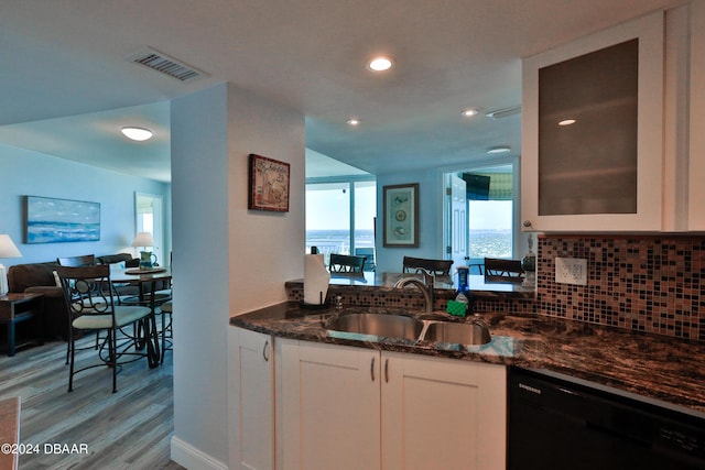 2625 S Atlantic Ave Unit 25Nw, Daytona Beach Shores, FL 32118 - kitchen featuring dishwasher, a sink, dark stone countertops, tasteful backsplash, and white cabinets