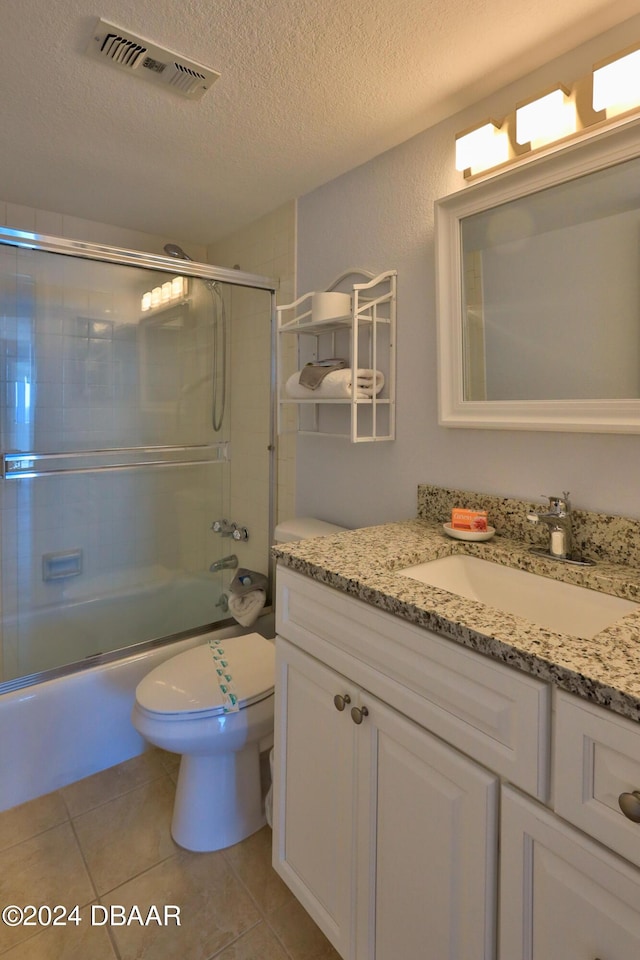 2625 S Atlantic Ave Unit 25Nw, Daytona Beach Shores, FL 32118 - full bath featuring a textured ceiling, vanity, bath / shower combo with glass door, toilet, and tile patterned floors