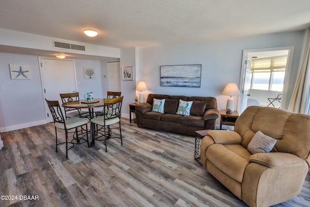 living room with hardwood / wood-style floors and a textured ceiling