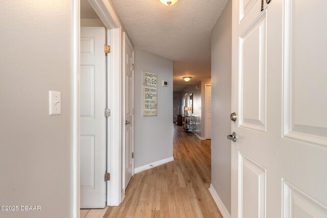 5300 S Atlantic Ave Unit 1-603, New Smyrna Beach, FL 32169 - hallway featuring light wood finished floors, baseboards, and a textured ceiling