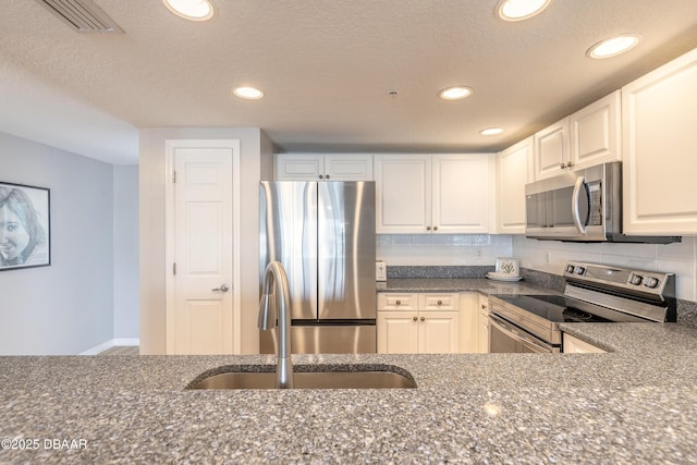 5300 S Atlantic Ave Unit 1-603, New Smyrna Beach, FL 32169 - kitchen featuring appliances with stainless steel finishes, a sink, recessed lighting, dark stone countertops, and decorative backsplash