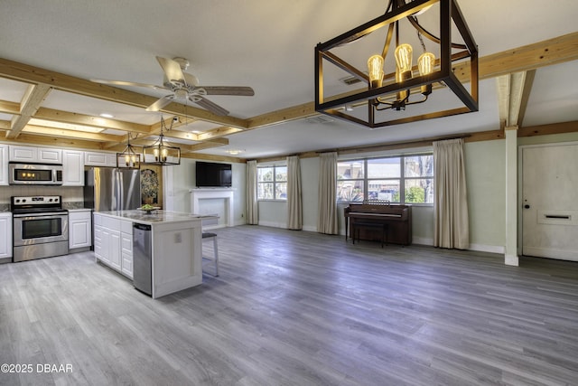 kitchen featuring a center island, white cabinetry, light wood-type flooring, plenty of natural light, and stainless steel appliances