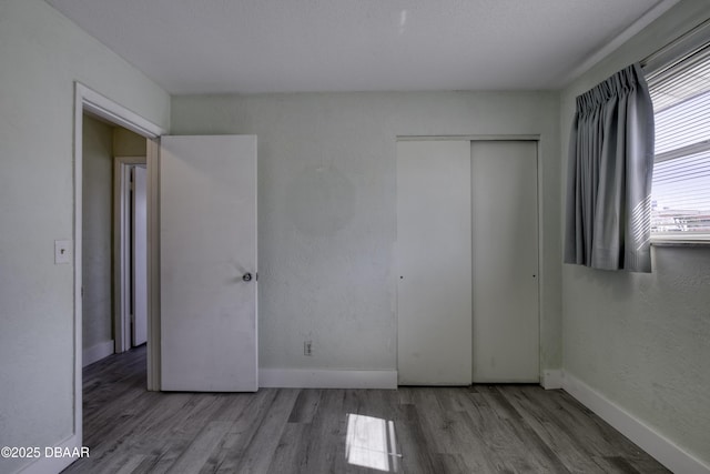 unfurnished bedroom with hardwood / wood-style floors and a closet