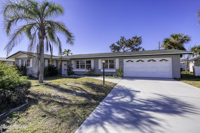 ranch-style home featuring a garage and a front lawn