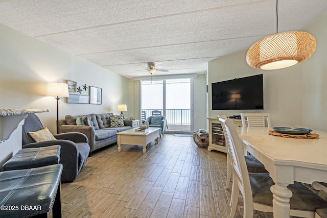 4453 S Atlantic Ave Unit 502, Port Orange, FL 32127 - living room featuring a ceiling fan, a textured ceiling, and wood finished floors