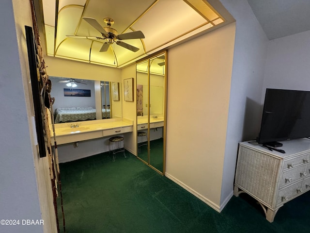 unfurnished bedroom featuring dark colored carpet, ceiling fan, sink, and a closet