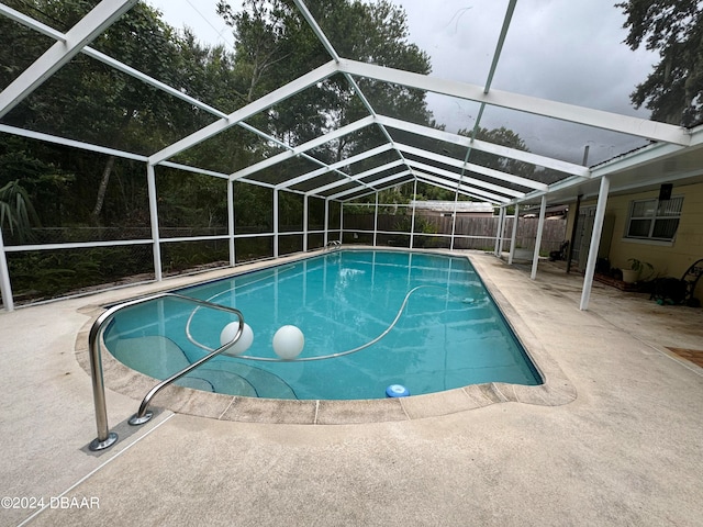 view of pool featuring glass enclosure and a patio